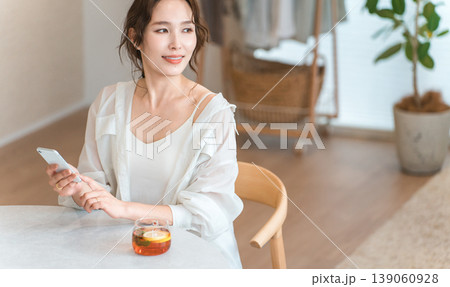 リビングのダイニングテーブルでティータイムにくつろぐおしゃれな女性 リビングのダイニングテーブルでティータイムにくつろぐおしゃれな女性 139060928