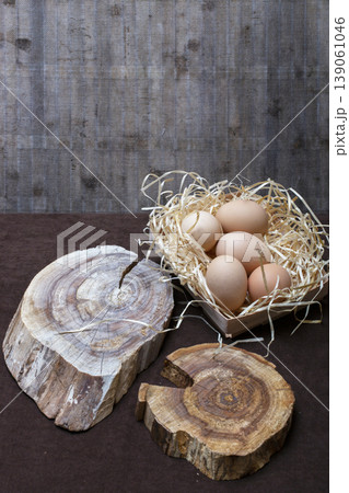 Chicken eggs and two wooden slices on a brown table 139061046
