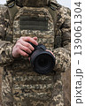 Soldier holding camera in field military photographer 139061304