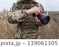 Soldier holding camera in field military photographer 139061305