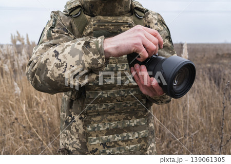 Soldier holding camera in field military photographer Soldier holding camera in field military photographer 139061305