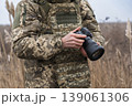 Soldier holding camera in field military photographer 139061306