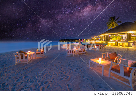 Dreamy night beach bar milky way starry sky lights calm ocean horizon summer travel tourism background relaxing fun outdoors chairs tables paradise destination Dreamy night beach bar milky way starry sky lights calm ocean horizon summer travel tourism background relaxing fun outdoors chairs tables paradise destination 139061749