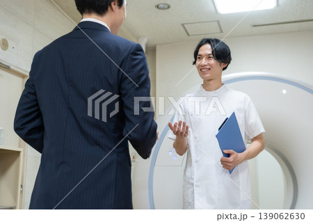 病院のCTをメンテナンスするビジネスマンと医者　撮影協力：学校法人電波学園　東京電子専門学校 139062630