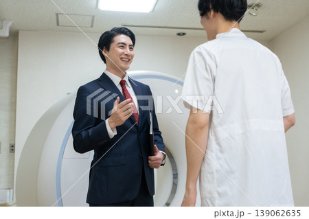 病院のCTをメンテナンスするビジネスマンと医者 撮影協力:学校法人電波学園 東京電子専門学校 病院のCTをメンテナンスするビジネスマンと医者 撮影協力:学校法人電波学園 東京電子専門学校 139062635