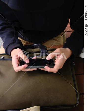 スマホを見ている男性の手元 139063549