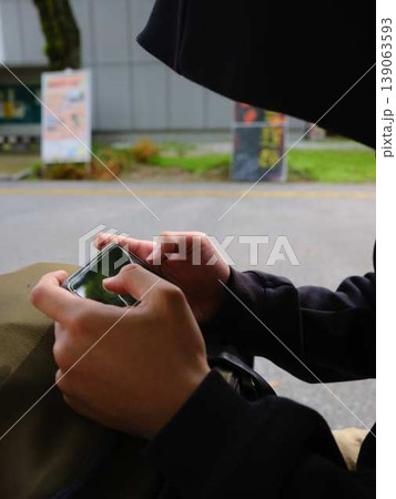 スマホを見ている男性の手元 139063593
