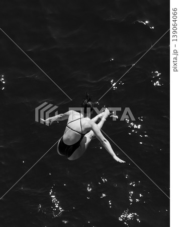 a professional female diver is jumping off a cliff into the sea a professional female diver is jumping off a cliff into the sea 139064066