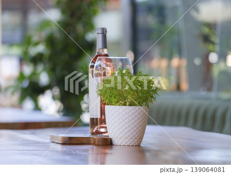 green plant and wine bottle on wooden table green plant and wine bottle on wooden table 139064081