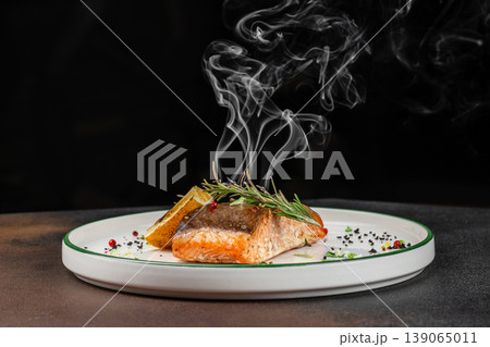 Grilled salmon fillet with steam rosemary and lemon on plate fine dining 139065011
