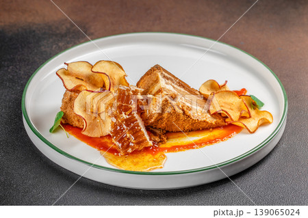 Honey cake dessert with dried apple chips and honeycomb on plate Honey cake dessert with dried apple chips and honeycomb on plate 139065024