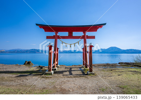 秋田・田沢湖畔に佇む御座石神社の鳥居と湖面に映える田沢湖ブルーの絶景 秋田・田沢湖畔に佇む御座石神社の鳥居と湖面に映える田沢湖ブルーの絶景 139065433