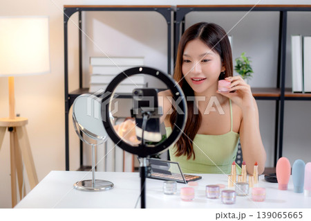 Young asian woman presenting and review cosmetic product with excitement on social media. 139065665