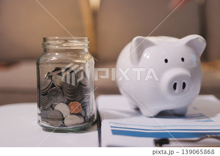 Happy asian young couple love hand calculate, putting coin in piggy bank for saving money to buy real estate for new home. Business finance, deposit with banking for financial planning future together 139065868