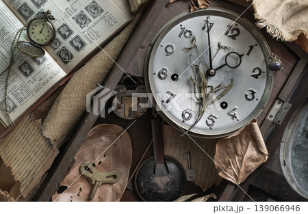 This vintage tableau captures the dark academia aesthetic, pairing cold mechanical relics with nature brittle fragility. At its heart lies a silenced clock face, its dial traced by a desiccated This vintage tableau captures the dark academia aesthetic, pairing cold mechanical relics with nature brittle fragility. At its heart lies a silenced clock face, its dial traced by a desiccated 139066946