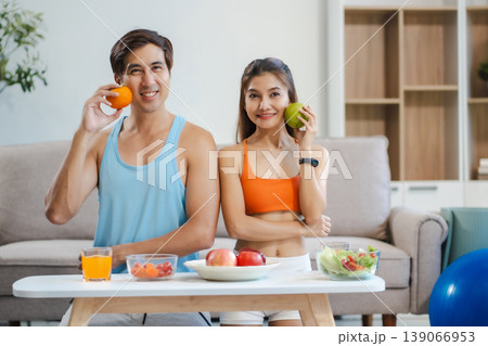 Fit couple enjoys healthy fruit breakfast after yoga training. fitness, nutrition, home lifestyle. 139066953