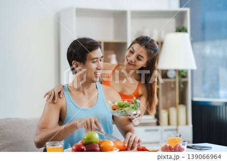Fit couple enjoys healthy fruit breakfast after yoga training. fitness, nutrition, home lifestyle. Fit couple enjoys healthy fruit breakfast after yoga training. fitness, nutrition, home lifestyle. 139066964