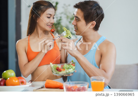 Fit couple enjoys healthy fruit breakfast after yoga training. fitness, nutrition, home lifestyle. Fit couple enjoys healthy fruit breakfast after yoga training. fitness, nutrition, home lifestyle. 139066965