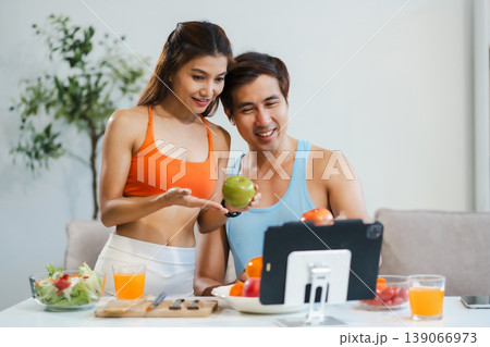 Fit couple enjoys healthy fruit breakfast after yoga training. fitness, nutrition, home lifestyle. Fit couple enjoys healthy fruit breakfast after yoga training. fitness, nutrition, home lifestyle. 139066973