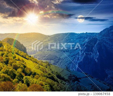 beautiful countryside. day meet night. sun and moon over wonderful springtime landscape in mountains. grassy field and rolling hills. rural scenery with steep forested slopes. epic highland wallpaper 139067458