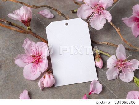 Spring blank gift tag mockup with pink cherry blossoms and twigs on grey stone, copy space 139069200