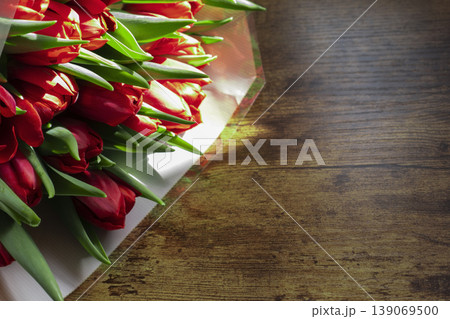 Beautiful red tulips on wooden table with natural warm sunlight Beautiful red tulips on wooden table with natural warm sunlight 139069500