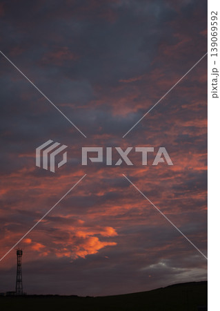 Silhouettes of hills and tower against dramatic fiery sky vertical format Silhouettes of hills and tower against dramatic fiery sky vertical format 139069592