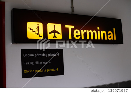 Terminal sign indicating stairs and airplane icon, with multilingual text for parking office level 4 in a modern airport setting Terminal sign indicating stairs and airplane icon, with multilingual text for parking office level 4 in a modern airport setting 139071957