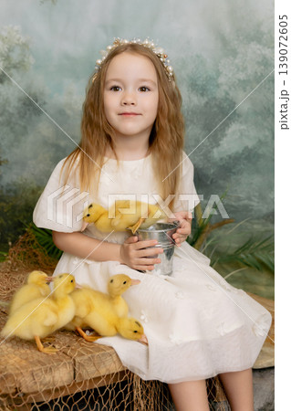 Cute girl holding tulips with ducklings, spring nature portrait with soft green background Cute girl holding tulips with ducklings, spring nature portrait with soft green background 139072605