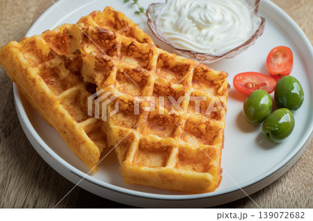 Crunchy waffle fries with sour cream dip served in a basket 139072682