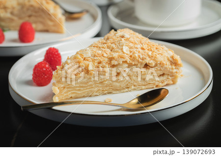 Sliced Napoleon cake on a white wooden table. Classic dessert Sliced Napoleon cake on a white wooden table. Classic dessert 139072693