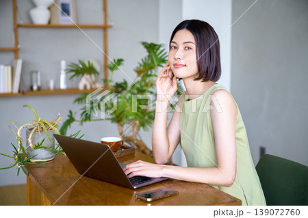 笑顔でPC作業をするアジア人女性のワークスタイル 笑顔でPC作業をするアジア人女性のワークスタイル 139072760