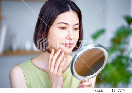 鏡で肌の状態を確認する若いアジア人女性 鏡で肌の状態を確認する若いアジア人女性 139072763