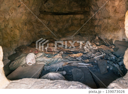 Interior view of an ancient Dargavs burial crypt, revealing human skeletal remains and deteriorated textiles Interior view of an ancient Dargavs burial crypt, revealing human skeletal remains and deteriorated textiles 139073026