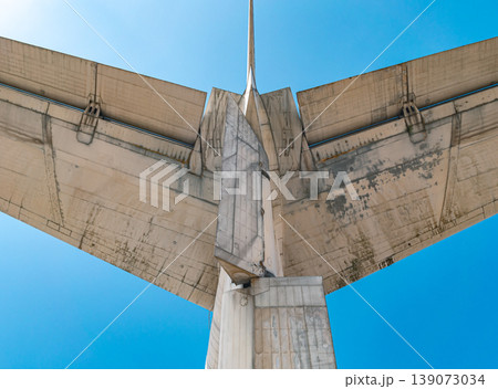 A close up upward view shows the dirty and aged underside of an airplane's horizontal and vertical tail stabilizers set against a blue sky. A close up upward view shows the dirty and aged underside of an airplane's horizontal and vertical tail stabilizers set against a blue sky. 139073034