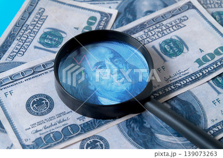 A magnifying glass on 100 dollar banknote for design. A magnifying glass on 100 dollar banknote for design. 139073263