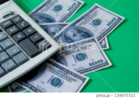 A calculator with banknote on color background. A calculator with banknote on color background. 139073321