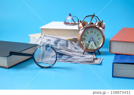A magnifying glass focus to bank note and alarm clock. A magnifying glass focus to bank note and alarm clock. 139073431