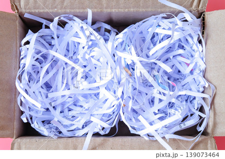 Shredded paper in cardboard box on color background. Shredded paper in cardboard box on color background. 139073464