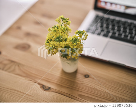 laptop and yellow flower on wooden table laptop and yellow flower on wooden table 139073536