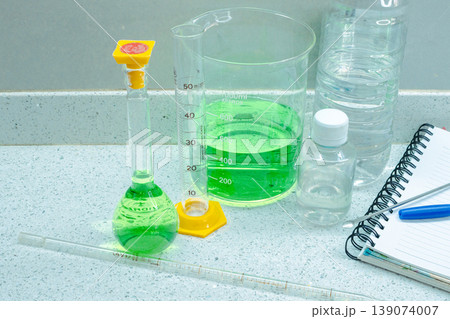 Laboratory instruments and solutions on a white countertop are prepared for chemical analysis, showcasing experimental procedures in a research and development setting Laboratory instruments and solutions on a white countertop are prepared for chemical analysis, showcasing experimental procedures in a research and development setting 139074007