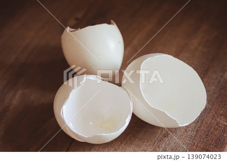 Cracked white eggshells on a wooden surface, showing the empty interior.Healthy cooking and sustainable kitchen waste concept Cracked white eggshells on a wooden surface, showing the empty interior.Healthy cooking and sustainable kitchen waste concept 139074023