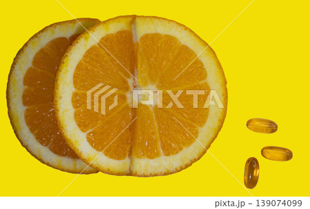 Shot from above of orange slice and Vitamin C capsules on yellow background. 139074099