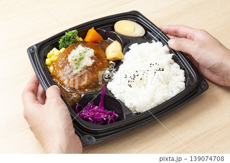 和風ハンバーグ弁当を持つ手元 139074708