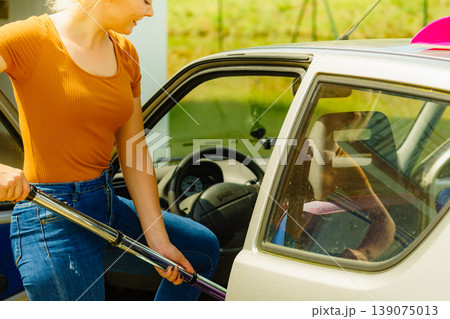 Cleaning car interior with vacuum cleaner 139075013