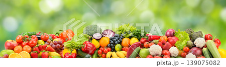 Bright Assortment of Fresh Fruits and Vegetables on Green Nature Background with Copy Space for Healthy Eating Themes Bright Assortment of Fresh Fruits and Vegetables on Green Nature Background with Copy Space for Healthy Eating Themes 139075082
