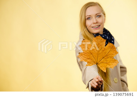 Woman holding orange autumn leaf Woman holding orange autumn leaf 139075691