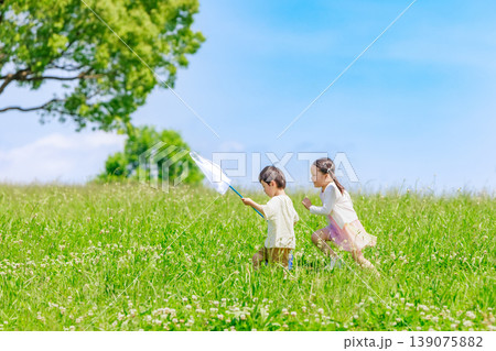 青空の草原で走り回って遊ぶ子供達 139075882