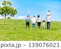 青空の草原を散歩する三世代家族 139076021