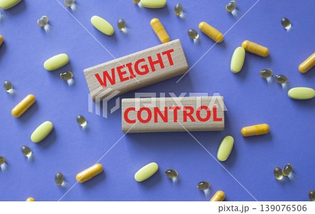 WEIGHT CONTROL symbol. Concept word WEIGHT CONTROL on wooden blocks. Beautiful purple background with pills. Medicine and WEIGHT CONTROL. Copy space WEIGHT CONTROL symbol. Concept word WEIGHT CONTROL on wooden blocks. Beautiful purple background with pills. Medicine and WEIGHT CONTROL. Copy space 139076506